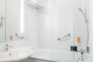 克拉科夫Vienna House Easy by Wyndham Cracow的白色的浴室设有水槽和淋浴。