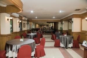 棉兰棉兰大酒店的一间带两张桌子和红色椅子的餐厅
