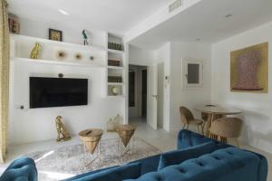 马拉加THE CLOCK HOUSE Luxury Urban Suites的客厅配有蓝色的沙发和桌子
