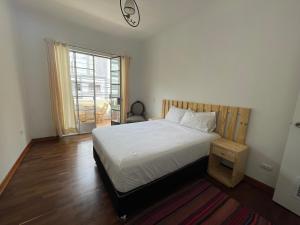 利马Casaroma Hostels的卧室配有白色的床和窗户。