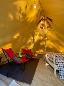 波讷地区圣朱利安Tente Indiana Pins - La Téouleyre的带椅子和床的帐篷客房