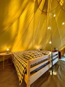 波讷地区圣朱利安Tente Indiana Pins - La Téouleyre的帐篷内一间卧室,配有一张床