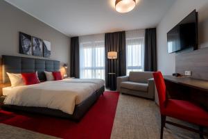 雷根斯堡Hotel INCLUDiO的酒店客房配有一张床、一把椅子和一张书桌