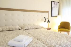 卡耐特蒂贝兰格卡内特普拉亚酒店的一间卧室配有一张床,上面有两条毛巾