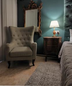 莫斯塔Julina Boutique Living的一间卧室配有椅子、镜子和一张床