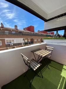 马德里Apartamento Cuzco的屋顶上两把椅子和一张桌子