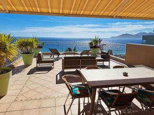 戛纳韦莱斯海滩公寓酒店的一个带桌椅的海景庭院