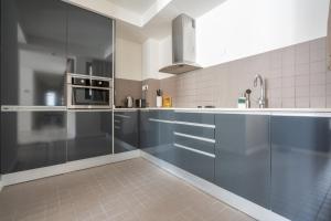 巴塞罗那limehome Barcelona Rector Triadó的一间设有蓝色橱柜和水槽的大厨房