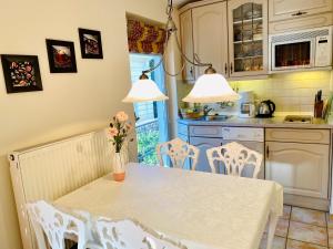 黑灵斯多夫Residenz Bleichröder - Ferienwohnung 17的厨房配有白色的桌椅