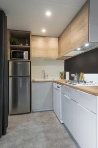 玛里纳罗米亚Sole Family Camping Village的厨房配有白色橱柜和不锈钢冰箱