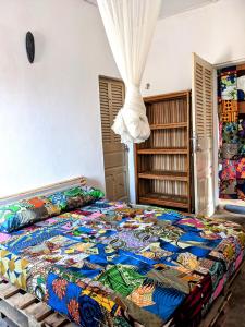 波多诺伏Chambres d'hôtes - Chez Mama Sêdjro的一间卧室配有一张大床和五颜六色的被子