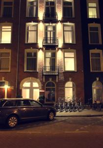 阿姆斯特丹萨拉精品酒店的停在大楼前的一辆汽车,车停在前面
