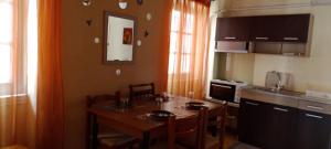 MantoúkionDora's happy apartment的带桌椅的厨房和带吧台的厨房