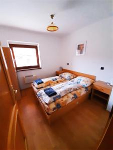 维塔诺瓦Apartmány Goral Oravice的一间卧室配有一张床、一张桌子和一个窗户。
