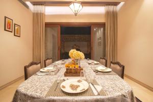 阿姆利则Ekant Villa with Pvt Pool at Amritsar by StayVista的餐桌,上面有桌布和鲜花