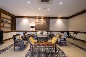 阿姆利则Ekant Villa with Pvt Pool at Amritsar by StayVista的带沙发和椅子的客厅以及电视