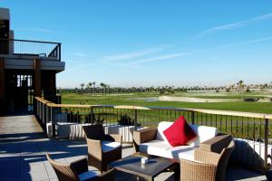 圣哈维耶尔El Oasis de las Palmeras @ Roda Golf & Beach resort的一个带沙发和椅子的庭院和一个高尔夫球场