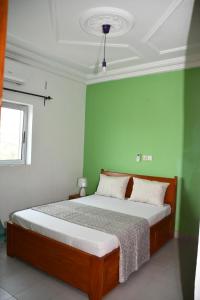 杜阿拉Spetiv Guesthouse的一间卧室设有一张带绿色墙壁的床
