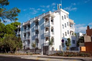 埃斯普霍斯Apartamentos Top Secret Prestige Es Pujols - Formentera Vacaciones的一座白色的建筑,上面有一座塔
