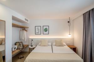 埃斯普霍斯Apartamentos Top Secret Prestige Es Pujols - Formentera Vacaciones的卧室配有一张白色大床
