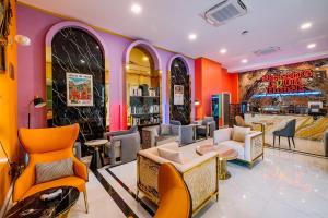 那空拍侬府Mekong Heritage Hotel的餐厅拥有橙色和紫色的墙壁和椅子