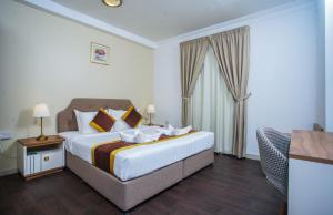 多哈别墅套房酒店的一间卧室配有一张特大号床和一张沙发
