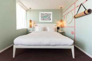 阿姆斯特丹意识酒店的卧室配有白色的床和窗户。