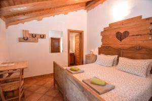 莱维科特尔梅Agritur Airone Bed & Camping的一间卧室配有一张大床和木制床头板