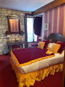 巴黎德尚帕涅大酒店的一间卧室配有一张大床,提供黄色和红色枕头