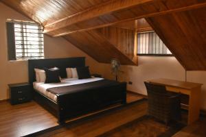 坎帕拉Beautiful home opposite Speke Resort Munyonyo near Lake Victoria的一间卧室配有一张床和一张书桌