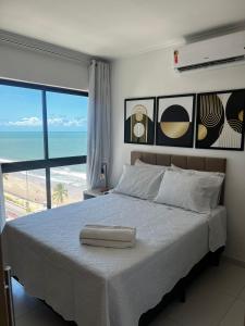 累西腓Beira-Mar Boa Viagem - Ivone Asfora by Bnb Flex的一间卧室配有一张床,享有海滩美景