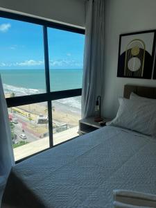 累西腓Beira-Mar Boa Viagem - Ivone Asfora by Bnb Flex的一间卧室配有一张床,享有海景