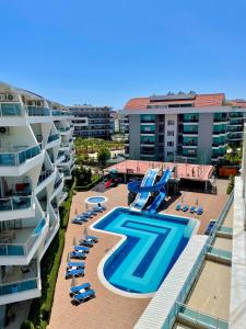 阿拉尼亚SA Apartments! Crystal Family Suites的一座带游泳池、椅子和建筑的度假村