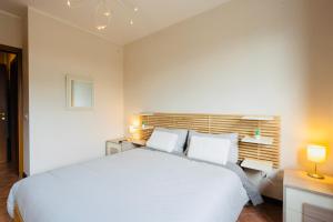 InfernettoAdventure Rent Apartment • Rome的一间卧室配有一张带两盏灯的大型白色床。