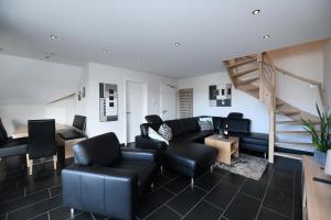 LonguichWeingut Heinen的客厅配有黑色家具和楼梯