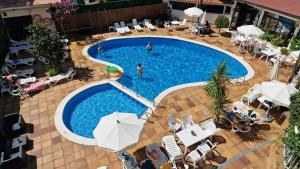 罗列特海岸Hotel Mireia的享有带椅子和遮阳伞的游泳池的上方景色