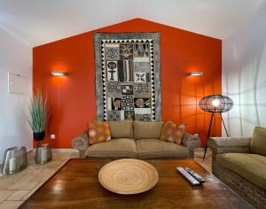 赞布热拉-杜马尔Herdade do Kuanza的客厅设有橙色墙壁和沙发