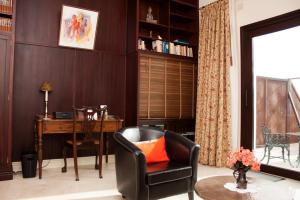 米哈斯Hotel Villarocamar的客厅配有书桌和带橙色枕头的椅子