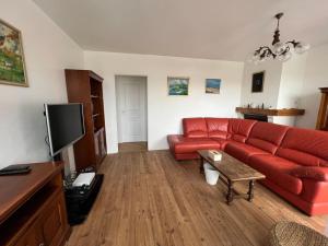 洛尔蒙Maison indépendante avec 6 chambres proche du tram A的客厅配有红色沙发和电视