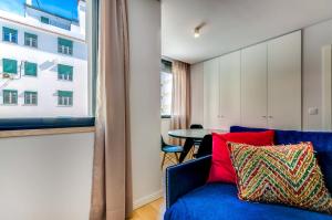 里斯本里斯本服务公寓 - 里博瑞戴德的客厅设有蓝色的沙发和窗户。
