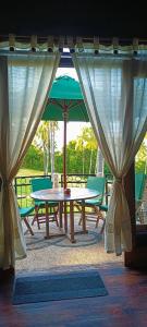 PawenangVilla Pintu Bintang的一张带绿伞和两把椅子的野餐桌