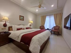 伊斯兰堡Welcome Hotel Islamabad的一间卧室设有一张大床和一个窗户。