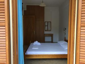 GialiskariNiko's Apartments A1的卧室配有白色床和蓝色窗帘