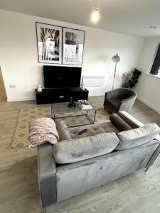 曼彻斯特Luxurious City View Apartment in Salford的带沙发和电视的客厅