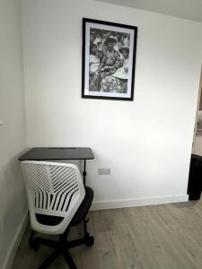 曼彻斯特Luxurious City View Apartment in Salford的一张桌子、椅子和墙上的照片
