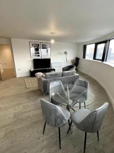 曼彻斯特Luxurious City View Apartment in Salford的客厅配有沙发和桌椅