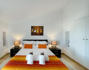 赞布热拉-杜马尔Herdade do Kuanza的一间卧室配有一张带两盏灯的大型白色床。