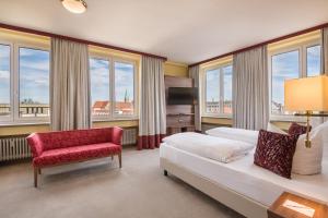 奥格斯堡Best Western Hotel Augusta的一间卧室配有一张床、一把椅子和窗户。