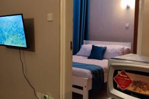 KiambuOne bedroom fully furnished apartment的客房设有1张带电视的床和1张带