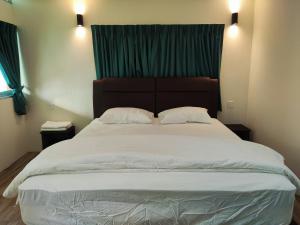 巴特沃思Rainbow Huts by Zing Motel的卧室内的一张大床,配有绿色窗帘